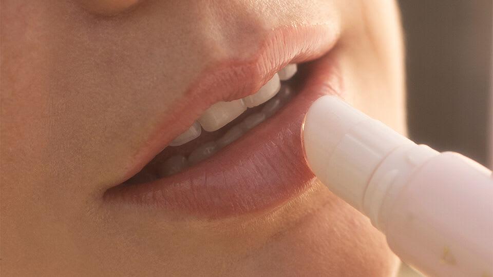 Model applying Kissu Lip Treament on lips.