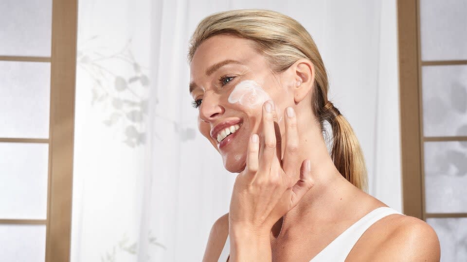 Model applying The Silk Serum on face.