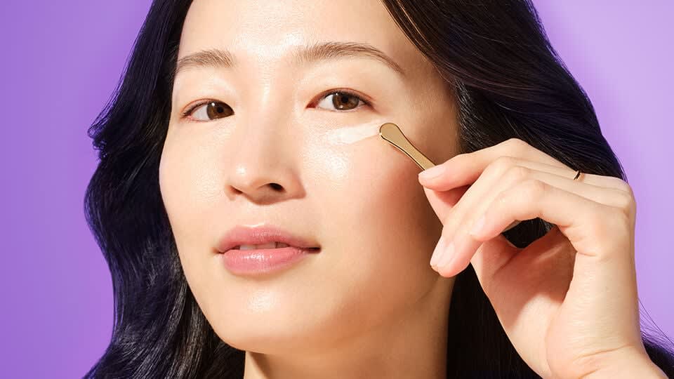 Model applying The Brightening Eye Cream.