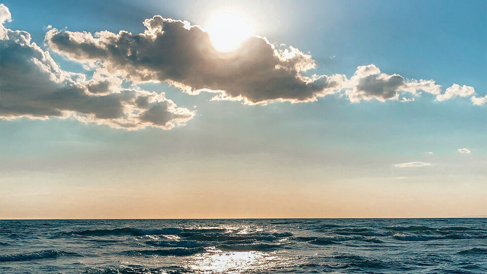 Ocean view with sun in the background.
