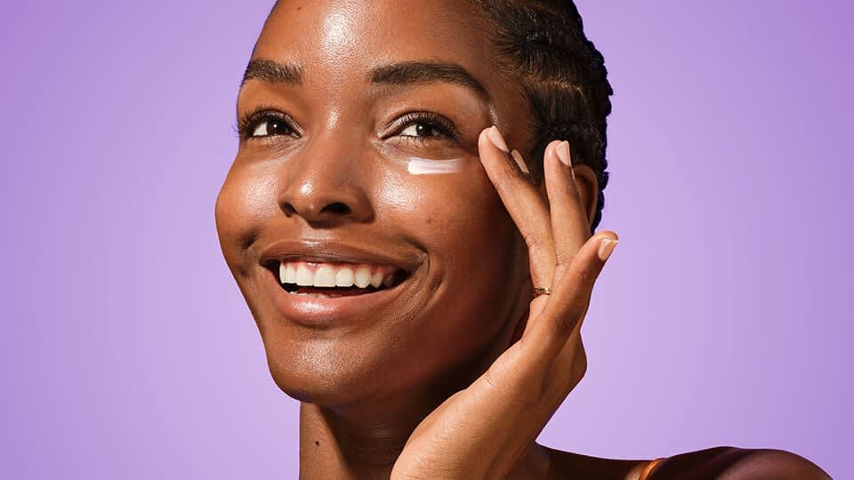 Model applying The Brightening Eye Cream.