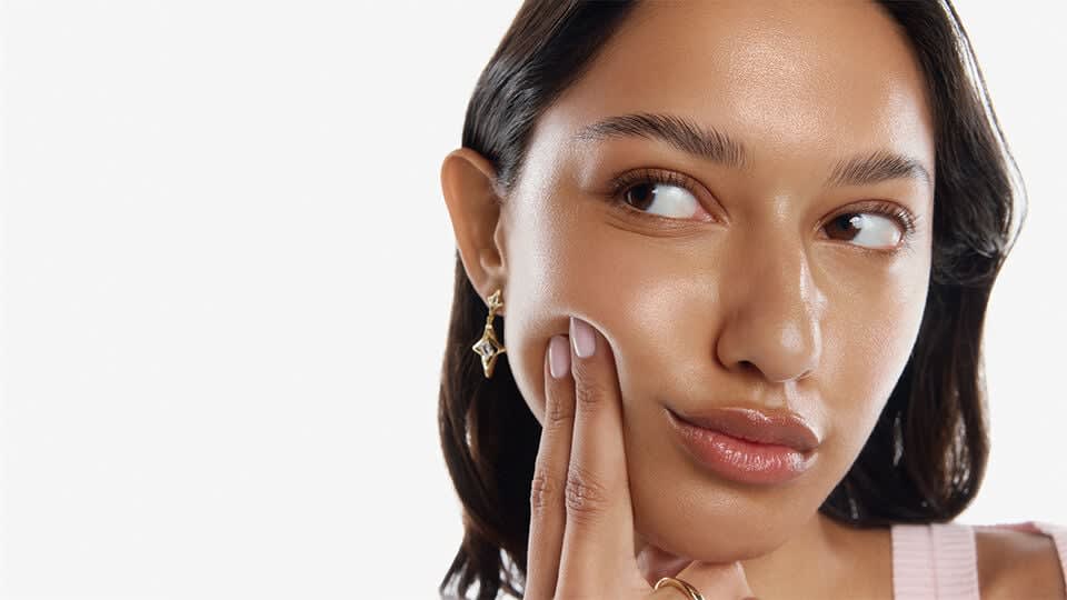 Model touching cheek.