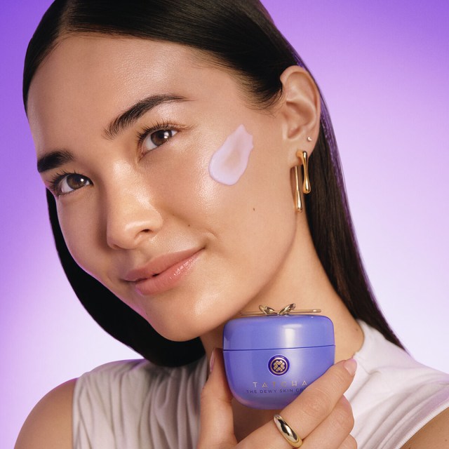 Woman applying The Dewy Skin Cream to her face