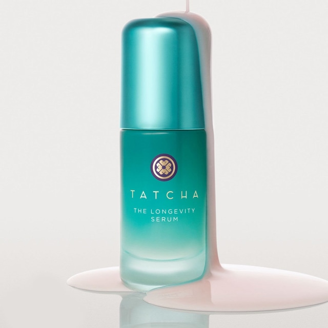 Shot of model applying The Longevity Serum onto face.